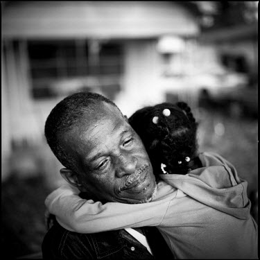 A man carries his granddaughter outside of his home in Joppa, Texas.