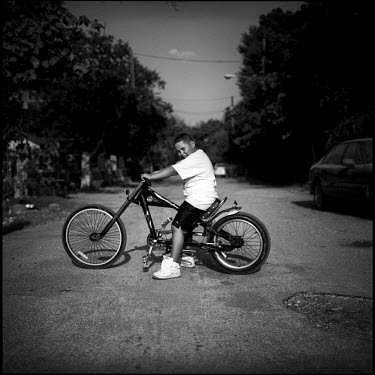A young boy shows off his new cruiser bike on a street in Joppa, Texas.