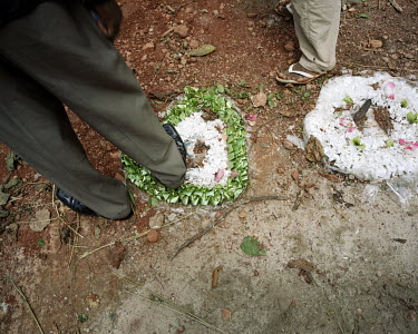 A man attending the funeral of Amma Serwaa (38) accidentally stands of a graveside bouquet.
