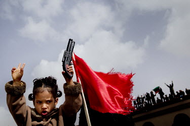 A young girl holds a toy gun as people gather after Friday prayers at Tobruk's central mosque shouting anti-Gaddafi slogans. They then marched heavily armed through the streets. On 17 February the cou...