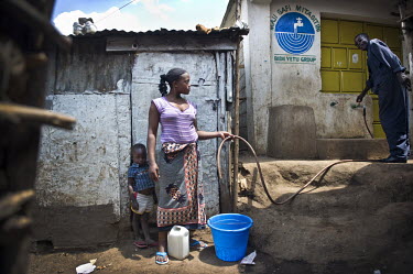 A woman and her son, residents of Kibera, Nairobi's biggest slum, queue at a water standpipe to buy their daily supplies.