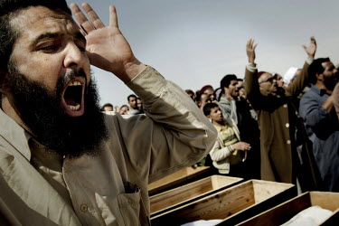 A man shouts next to coffins at a mass funeral for six people who died during fighting between Gaddafi's forces and the rebels for the control of the city of Brega. Around 500 people attended the fune...