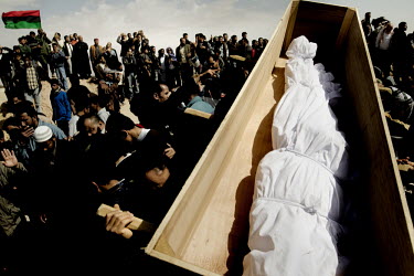 A bound body in a coffin being held up at a mass funeral for six people who died during fighting between Gaddafi's forces and the rebels for the control of the city of Brega. Around 500 people attende...