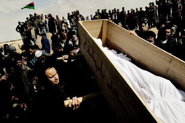 A bound body in a coffin being held up at a mass funeral for six people who died during fighting between Gaddafi's forces and the rebels for the control of the city of Brega. Around 500 people attende...