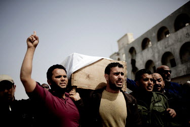 Men carry a coffin at a mass funeral for approximately 20 people who died on the evening of March 4, when a huge deposit of ammunition exploded outside of Benghazi. Rebels claim that it was Gaddafi's...