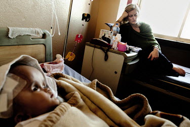 Cecilie (right) sleeps as she prepares to leave the Annapurna Neurological Institute in Kathmandu. She is exhausted and worried. Victoria (left) had surgery two days ago when 1.5 litres of fluid was d...