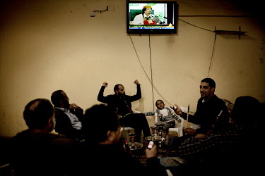 A man cheers as he listens to the latest news about the uprising against the 40 year rule of Col Muammar Gadaffi on Aljazeera news channel in a traditional tea house in Tobruk, one of a number of citi...