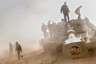 Men search a destroyed tank, blown up during an air strike against pro Gaddafi forces by the French military while enforcing a no fly zone over Libya. On 17 February 2011 Libya saw the beginnings of a...