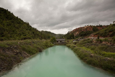 An acid pond at a heavy rare earth elements mining facility in Longnan County near Ganzhou. The acid has been drip fed into the top of the mountain and leached through the clay to process out the heav...