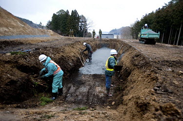 Workers digging a pit next to a Buddhist temple to be used as a mass grave for unidentified victims of the quake and Tsunami. On 11 March 2011 a magnitude 9 earthquake struck 130 km off the coast of N...