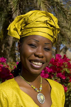 A Wolof woman wearing a bright yellow outfit.