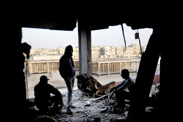 A resident of a flat and two friends in the living room of a house that was partly destroyed by a missile fired by pro-Gadaffi forces. According to the family living in there no rebels were fighting f...