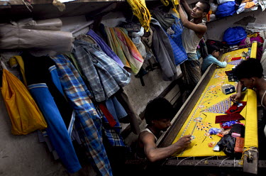Migrant workers from the Indian state of Bihar decorate a textile in an embroidery workshop in Dharavi, India's biggest slum. Numerous such workshops operate in Dharavi producing all manner of goods t...