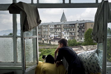 A young man, with a cat, looks out of the window of his mother's apartment in Shusha during his last summer holiday before joining the Military School in Yerevan. The Nagorno-Karabakh Republic (NKR) i...
