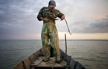 Branza Victor, a 42 year old fisherman, prepares his waterproofs before he enters Lake Razim to pull out fishing nets. Most of local fishermen are Lipovani, descendants of migrants who left Russia in...