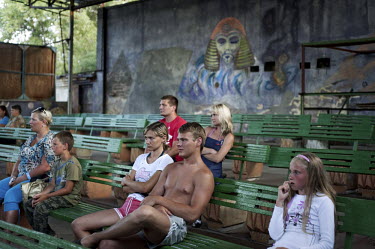 Young tourists watch a circus show during the summer holidays in the Black Sea resort town of Zatoka.