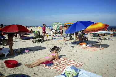 Tourists sunbathe on the beach in the Black Sea resort town of Zatoka.