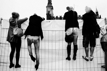 People look over an wall at an event during Copenhagen Fashion Week.
