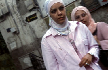 Two veiled young women wearing lots of pink clothes.