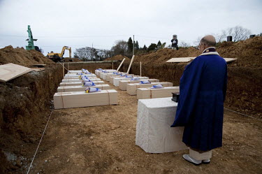 A monk recites a Buddhist sutra during a burial ceremony of unidentified bodies in Yamamoto. On 11 March 2011 a magnitude 9 earthquake struck 130 km off the coast of Northern Japan causing a massive T...