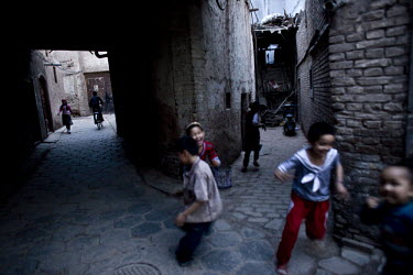 Children play on a street in the old city in Kashgar. The old city, where Uighur (Uyghur) people have lived and worked for centuries, is being demolished for reconstruction under the government's proj...