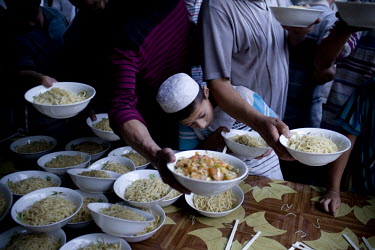 Uighur (Uyghur) people receive a free meal at a mosque before the break of Ramadan in Hotan.