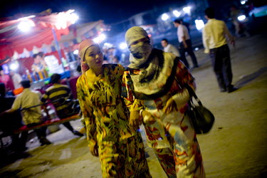 Uighur (Uyghur) women make their way through a night market in Yarkand.