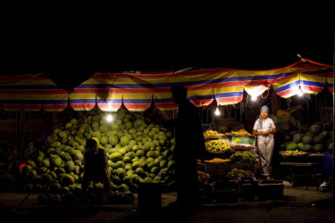 Uighur (Uyghur) people work and shop at a night market selling vegetables in Xinjiang.