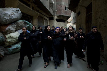 Family members walk to a Coptic Christian mass funeral at St Simon the Tanner's Church in Mokattam, Cairo. The funeral is for 11 young protesters who were killed by the army during a protest against t...