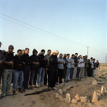 Rebels pray for several bodies found in shallow graves on the road near Brega. On 17 February 2011 Libya saw the beginnings of a revolution against the 41 year regime of Col Muammar Gaddafi.