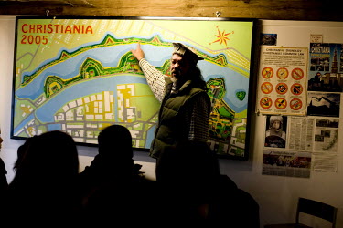 A tour guide points to a map of the Christiania neighbourhood of Copenhagen.