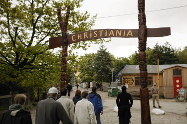 People go through the main entrance to the Christiania neighbourhood of Copenhagen.