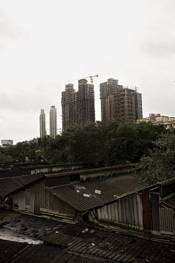 Skyscrapers under construction in Mumbai's financial district tower over a group of dilapidated old buildings.