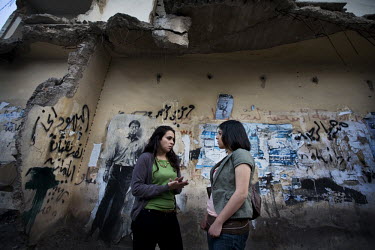 Shirin (left) and Liana, both members of the 15th of March movement, talk to one another on a street. The movement's idea is for political parties Hamas and Fatah to merge and fight together for Pales...