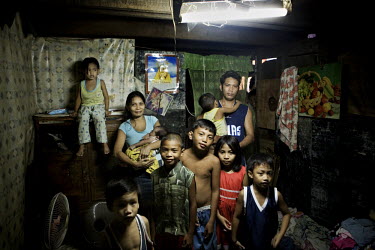 The Esponilla family in their house in Santo Nino, Manila. Bhona and Charito Esponilla have around 20 square meters of space to share with their children. People in this area live in small homemade hu...