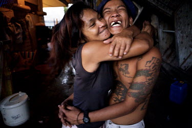 Anna and Renan hug each other in their home where they live with their five children, situated beneath a bridge in the neighbourhood of Quiapo. They collect rubbish such as used plastic bottles and sc...
