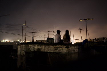 On a rooftop a young couple have a quiet moment of privacy in the Vitas slum near the Smokey Mountains rubbish dump. Many people here live from collecting garbage such as used plastic bottles and scra...
