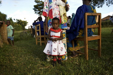 A small child waits with parents to collect tablets during the Mother and Child Health Week held in April 2010. This includes a mass drug administration against intestinal worms and schistosomiasis. A...