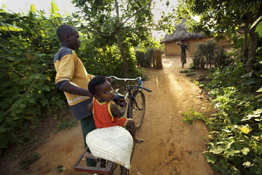 A small child is pushed along on a bike in Ruzo Cell. Gaharwa Lake, during the Mother and Child Health Week held in April 2010. This includes a mass drug administration against intestinal worms and sc...