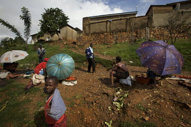 Women and children use parasols as shade outside of their homes in Kigali, Rwanda, during the Mother and Child Health Week held in April 2010. This includes a mass drug administration against intestin...