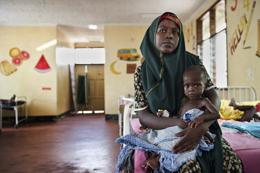 A woman holds her baby in the supplementary feeding ward at a hospital run by IRC (the International Rescue Committee) at Dadaab refugee camp. Since Al Shabaab, an Islamic militia with alleged links t...