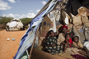 A family sit in their makeshift tent, given to them by the United Nations at Dadaab refugee camp. Since Al Shabaab, an Islamic militia with alleged links to Al Qaida, is controlling large parts of Som...