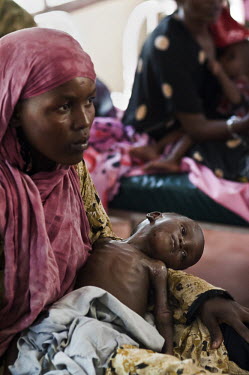 A woman holds her malnourished baby in the supplementary feeding ward at a hospital run by IRC (the International Rescue Committee) at Dadaab refugee camp. Since Al Shabaab, an Islamic militia with al...