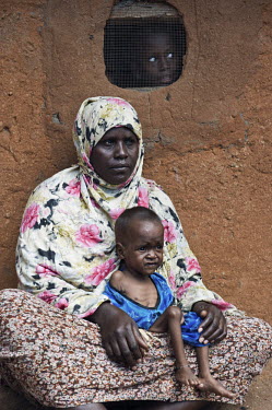 A mother holds her malnourished child in front of their hut at Dadaab refugee camp. Since Al Shabaab, an Islamic militia with alleged links to Al Qaida, is controlling large parts of Somalia and impos...