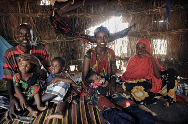 A family sit in their makeshift shelter at Dadaab refugee camp. Since Al Shabaab, an Islamic militia with alleged links to Al Qaida, is controlling large parts of Somalia and imposing tough Sharia law...