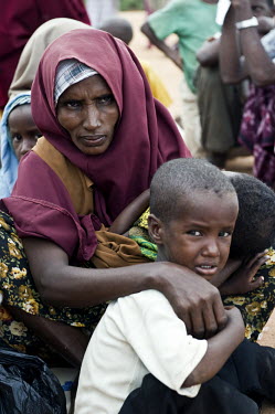 A mother sits with her children at Dadaab refugee camp. Since Al Shabaab, an Islamic militia with alleged links to Al Qaida, is controlling large parts of Somalia and imposing tough Sharia laws, many...