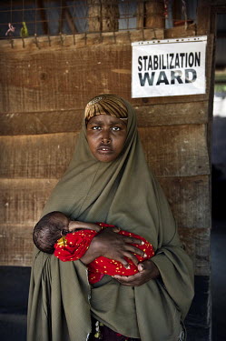 Malnourished 5 month old Abdi Farah who weighs only 2.2kg is held by her mother in the stabilisation ward at a hospital at Dadaab refugee camp. Since Al Shabaab, an Islamic militia with alleged links...