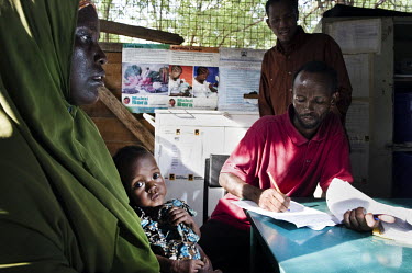 A health worker takes details of a malnourished child being held by it's mother in the stabilisation ward at a hospital at Dadaab refugee camp. Since Al Shabaab, an Islamic militia with alleged links...