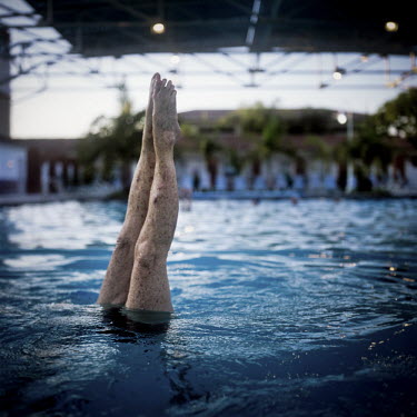 73 year old Margo Bouer does a handstand during an Aquadette practice at Laguna Woods, California. Margo suffers from severe MS, but says her nausea and shaking almost disappear when she is in the swi...