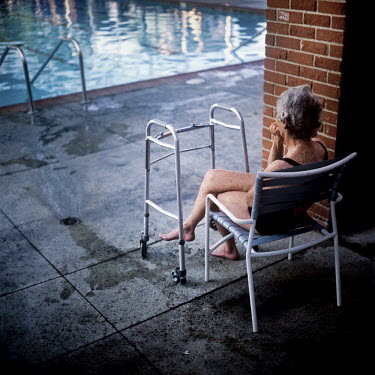 73 year old Margo Bouer resting on a chair by the pool during Aquadette practice at Laguna Woods, California. Margo suffers from severe MS, but says her nausea and shaking almost disappear when she is...